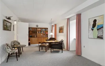 a living room with a table and chairs at Cozy Home In Brovst With Kitchen in Brovst