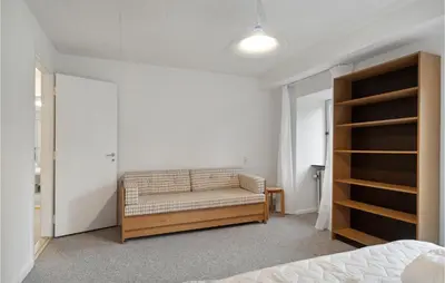 a bedroom with a bed and a couch in a room at Cozy Home In Brovst With Kitchen in Brovst