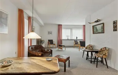 a living room with leather furniture and a table at Cozy Home In Brovst With Kitchen in Brovst