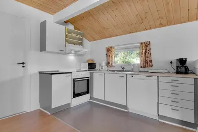 a kitchen with white appliances and a wooden ceiling at Skytten 5 - Environmentally Friendly Holiday Home in Hune