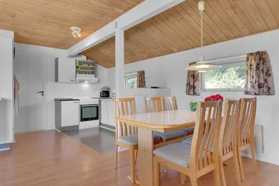 a kitchen and dining room with a wooden table and chairs at Skytten 5 - Environmentally Friendly Holiday Home in Hune