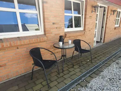 two chairs and a table on a patio at Stort værelse med tekøkken, tæt på hav og fjord. in Bedsted Thy