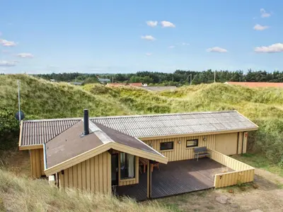 a house with a deck on the side of a hill at Holiday Home Riitta - 300m from the sea by Interhome in Løkken