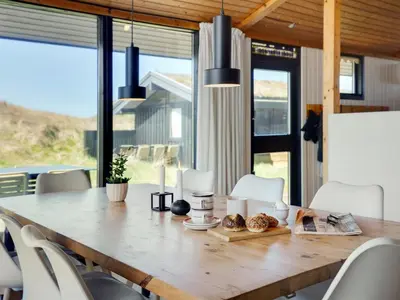 a dining room with a large wooden table with chairs at Holiday Home Ilmari - 190m from the sea by Interhome in Pandrup