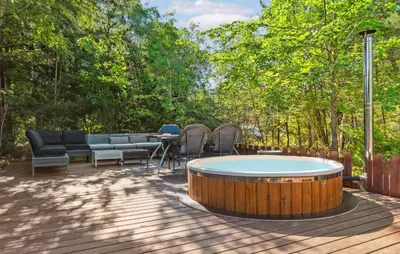a hot tub on a deck with chairs and a table at Lovely Home In Hurup Thy in Sønder Ydby