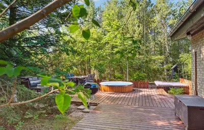 a deck with a hot tub and a table at Lovely Home In Hurup Thy in Sønder Ydby