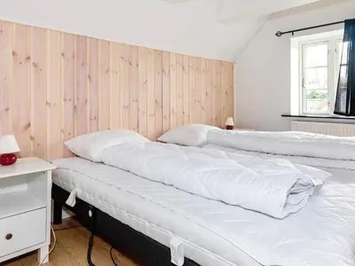 two beds in a room with wooden walls at 6 person holiday home in Thisted-By Traum in Thisted