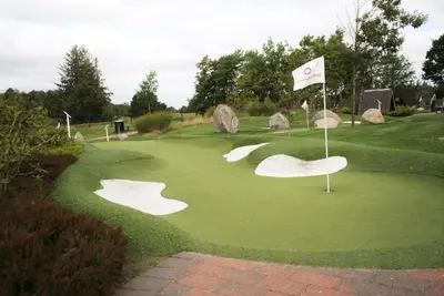 a golf course with a flag and a putting green at Nice holiday home in beautiful resort in Farsø