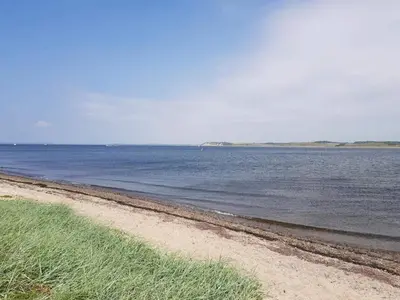 a beach with the ocean and grass on it at 8 person holiday home in Højslev-By Traum in Højslev