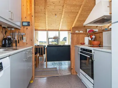 a kitchen with wooden walls and a large window at 9 person holiday home in Harboøre-By Traum in Harboør