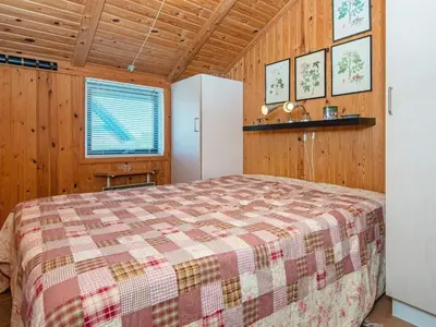 a bedroom with a bed and a refrigerator at 9 person holiday home in Harboøre-By Traum in Harboør