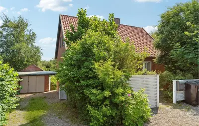 a large bush in front of a house at Beautiful Apartment In Hurup Thy in Heltborg
