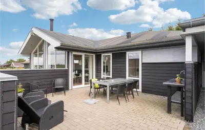 a house with a patio with a table and chairs at 3 Bedroom Lovely Home In Farsø in Farsø