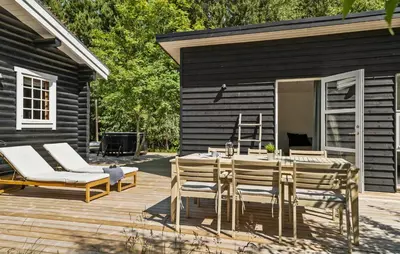 a wooden deck with a table and chairs and a house at Lovely Home In Højslev With Kitchen in Lundø