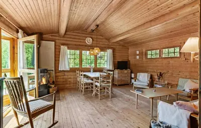 a living room with wooden walls and wooden floors at Lovely Home In Højslev With Kitchen in Lundø