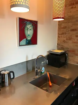 a kitchen with a sink and a painting on the wall at Holstebro Sky Studio in Holstebro