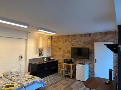 a room with a bed and a television and a table at Holstebro Sky Studio in Holstebro