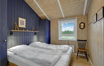 a bedroom with two beds and a chair in it at Holiday Home Bavnbak Thisted Iv in Thisted