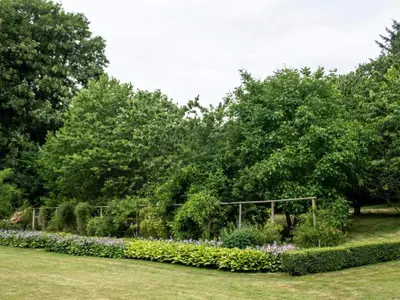 a garden with flowers and trees in a park at 8 person holiday home in Øster Assels-By Traum in Øster Assels