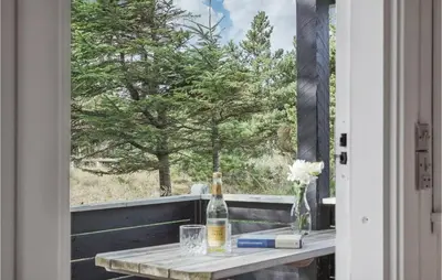 a table on a balcony with a view of a tree at Awesome Home In Saltum With Wifi in Saltum