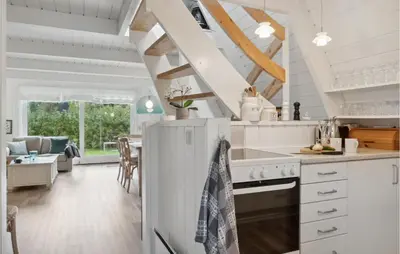 a kitchen with white appliances and a living room at Gorgeous Home In Farsø With Kitchen in Farsø