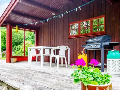 a porch with two chairs and a table and a grill at 6 person holiday home in Roslev-By Traum in Roslev