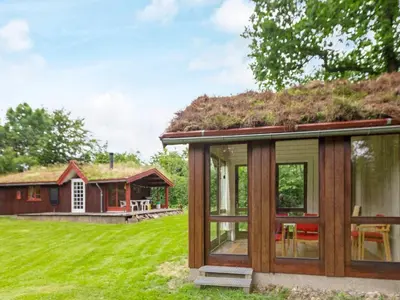 a cabin with a grass roof on a green field at 6 person holiday home in Roslev-By Traum in Roslev
