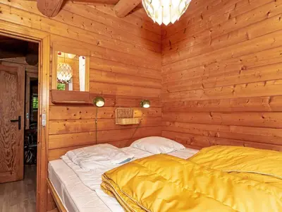 a bedroom with a bed in a wooden room at 6 person holiday home in Roslev-By Traum in Roslev