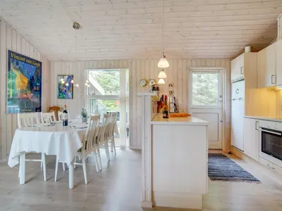 a kitchen and dining room with a table and chairs at Holiday Home Ønder - 800m from the sea by Interhome in Blokhus
