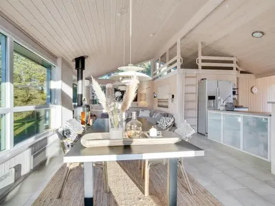 a kitchen and dining room with a table and chairs at Holiday Home Gun - 450m from the sea by Interhome in Blokhus