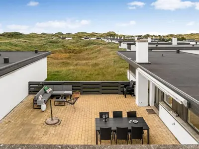 a balcony with tables and chairs on a roof at Holiday Home Tarvo - 400m from the sea by Interhome in Pandrup
