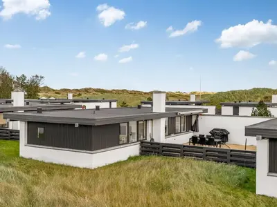 a house with a black and white roof at Holiday Home Tarvo - 400m from the sea by Interhome in Pandrup