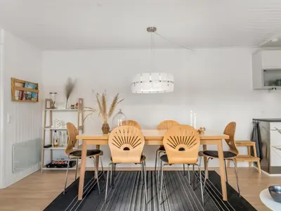 a dining room with a wooden table and chairs at Holiday Home Tarvo - 400m from the sea by Interhome in Pandrup