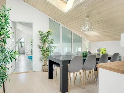 a dining room with a black table and chairs at Holiday Home Jenvold - 600m from the sea by Interhome in Torsted