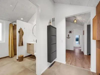 a room with white walls and a black cabinet at Holiday Home Ivar - 300m from the sea by Interhome in Harboør