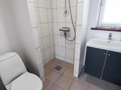a bathroom with a shower and a toilet and a sink at Holiday Home Ilkka - 400m from the sea by Interhome in Torsted