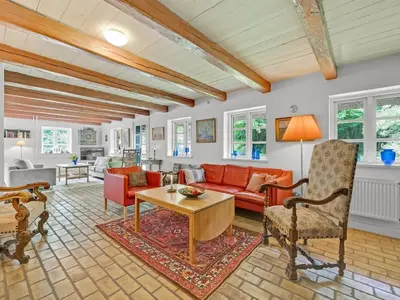 a living room with a red couch and a table at Holiday Home Tatiane - 10km from the sea by Interhome in Bækmarksbro