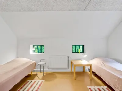 a white room with two beds and a table at Holiday Home Tatiane - 10km from the sea by Interhome in Bækmarksbro
