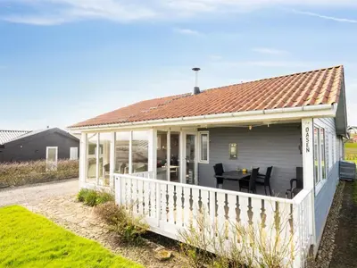 a small house with a deck with a table at Holiday Home Ormar - 100m to the fjord by Interhome in Lemvig