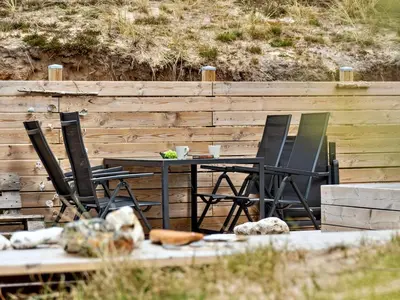a table and chairs sitting next to a wooden fence at Holiday Home Sulo - 1-4km from the sea by Interhome in Torsted