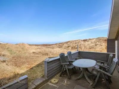 a table and chairs on a patio with the ocean at Holiday Home Hilmer - 250m from the sea by Interhome in Torsted