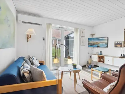 a living room with a blue couch and a table at Holiday Home Ubbe - 200m from the sea by Interhome in Lemvig