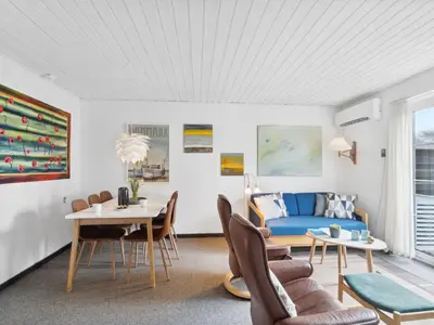 a living room with a blue couch and a table at Holiday Home Ubbe - 200m from the sea by Interhome in Lemvig