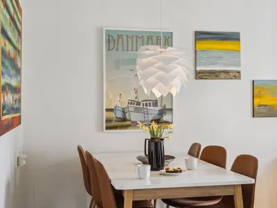 a dining room with a white table and chairs at Holiday Home Ubbe - 200m from the sea by Interhome in Lemvig
