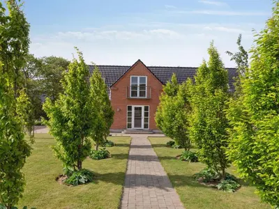 a brick house with a garden with trees in front at Apartment Dietlinde - 1-3km to the fjord by Interhome in Thyholm