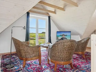 a room with a table and chairs on a rug at Apartment Dietlinde - 1-3km to the fjord by Interhome in Thyholm