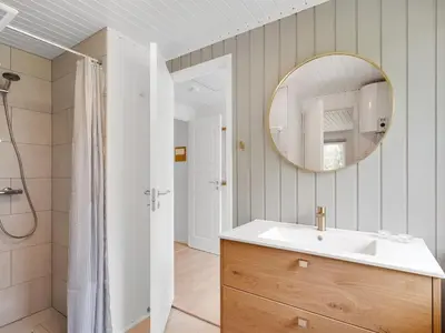 a bathroom with a sink and a mirror at Holiday Home Gudrid - 250m to the fjord by Interhome in Højslev