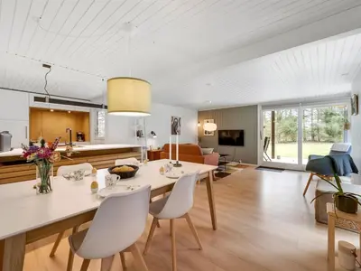 a kitchen and living room with a dining table and chairs at Holiday Home Gudrid - 250m to the fjord by Interhome in Højslev