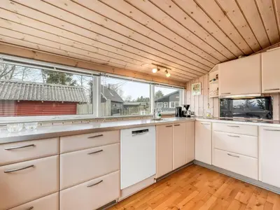 a kitchen with white cabinets and a large window at Holiday Home Bosi - 100m to the fjord by Interhome in Højslev