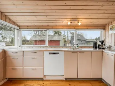 a kitchen with white cabinets and a large window at Holiday Home Bosi - 100m to the fjord by Interhome in Højslev